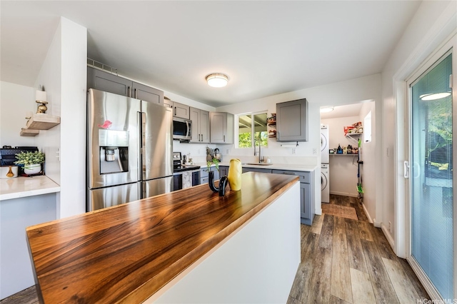 625 Maluniu Ave, Kailua, HI 96734 - kitchen with appliances with stainless steel finishes, gray cabinetry, dark wood-style flooring, a sink, and stacked washing machine and dryer