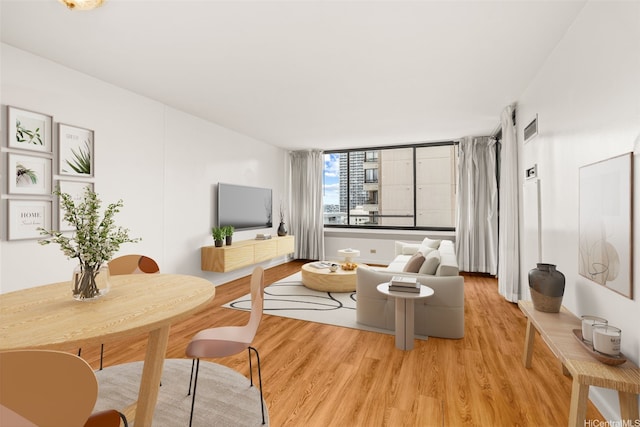 living area featuring visible vents and light wood-style floors