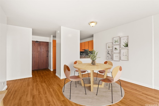 dining room with light wood finished floors and baseboards