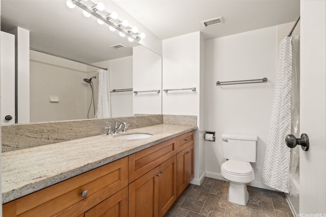 bathroom featuring vanity, baseboards, stone finish floor, and visible vents