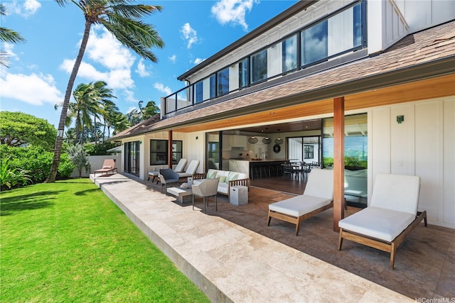 21 Kalaka Pl, Kailua, HI 96734 - rear view of house featuring a lawn, board and batten siding, a patio, an outdoor living space, and a balcony