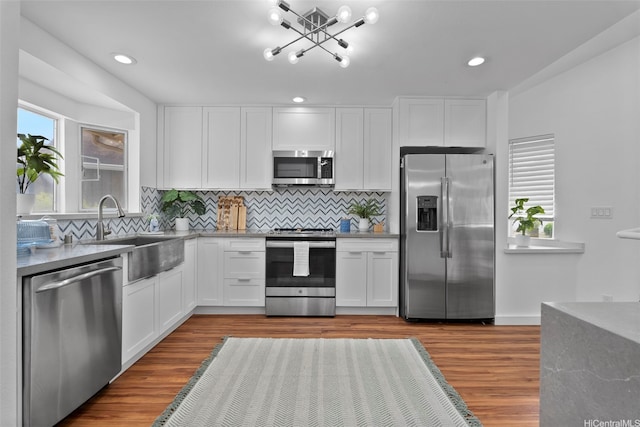 91-113 Kaakina Pl, Ewa Beach, HI 96706 - kitchen featuring stainless steel appliances, a sink, white cabinets, wood finished floors, and recessed lighting