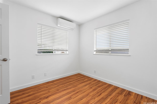 91-113 Kaakina Pl, Ewa Beach, HI 96706 - unfurnished room with a wall unit AC, healthy amount of natural light, wood finished floors, and baseboards