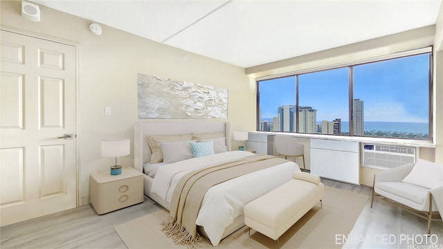 bedroom with wood finished floors, a view of skyline, and an AC wall unit