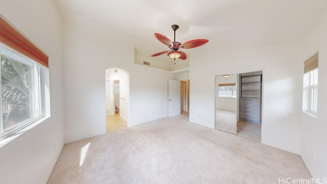91-1040 Kaihohonu St, Ewa Beach, HI 96706 - unfurnished bedroom featuring light carpet, arched walkways, a closet, a ceiling fan, and connected bathroom