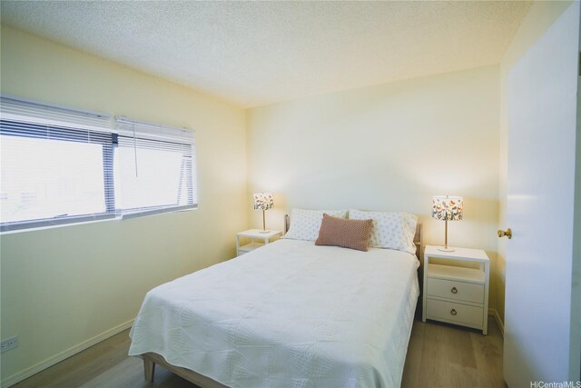 bedroom featuring wood finished floors and baseboards