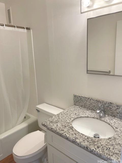 bathroom featuring vanity, toilet, shower / bath combo with shower curtain, and visible vents
