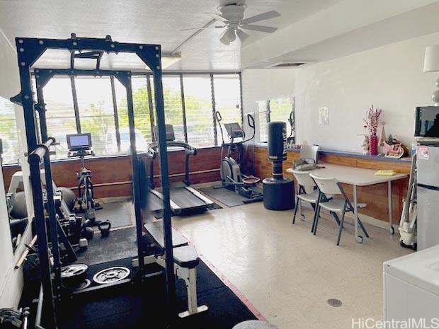 exercise room with a ceiling fan and a healthy amount of sunlight
