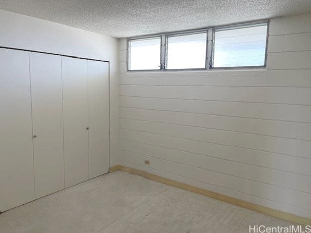 unfurnished bedroom featuring a closet and a textured ceiling