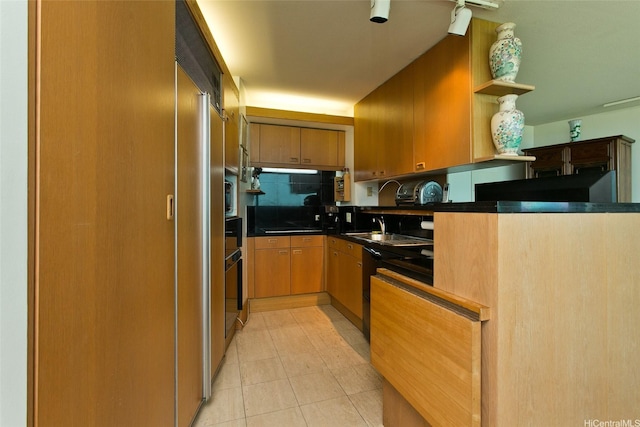 kitchen featuring a sink, dark countertops, open shelves, brown cabinets, and light tile patterned floors