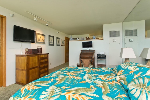 carpeted bedroom featuring rail lighting