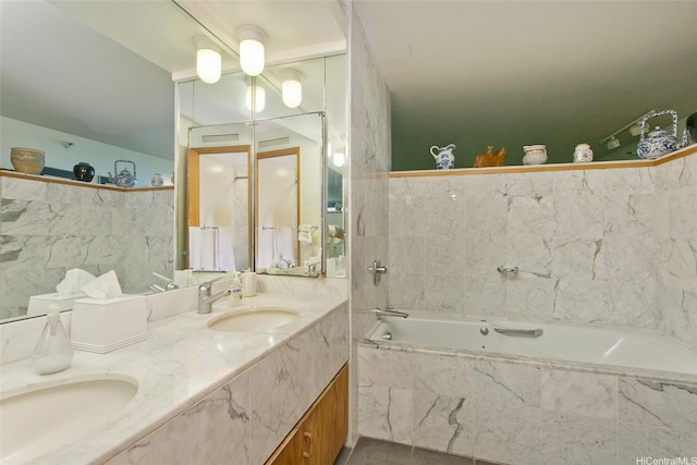 bathroom with a bath, double vanity, and tile walls