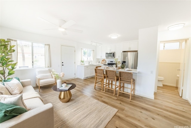 living room featuring light wood-style flooring and a ceiling fan