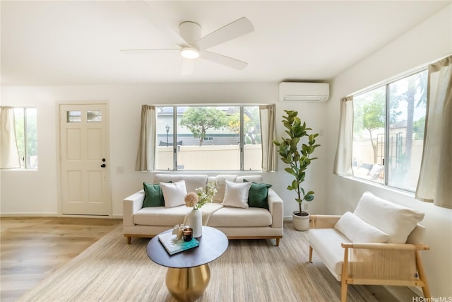 living area with a wall mounted air conditioner, baseboards, a ceiling fan, and wood finished floors