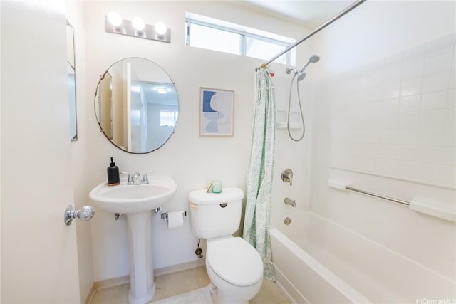 bathroom featuring shower / bath combo with shower curtain, toilet, a sink, and baseboards