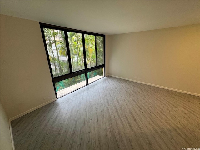 1441 Piikoi St Unit 206, Honolulu, HI 96822 - empty room featuring wood finished floors, baseboards, and a wall of windows