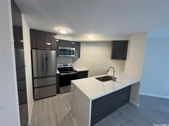 1441 Piikoi St Unit 206, Honolulu, HI 96822 - kitchen featuring appliances with stainless steel finishes, a sink, modern cabinets, and light wood finished floors