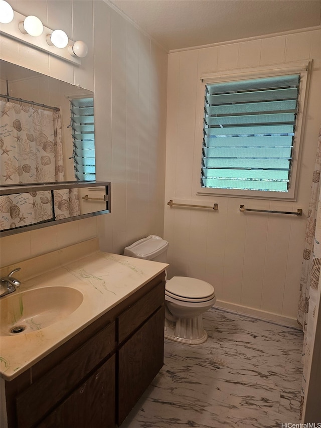 bathroom with toilet, a shower with curtain, marble finish floor, vanity, and ornamental molding