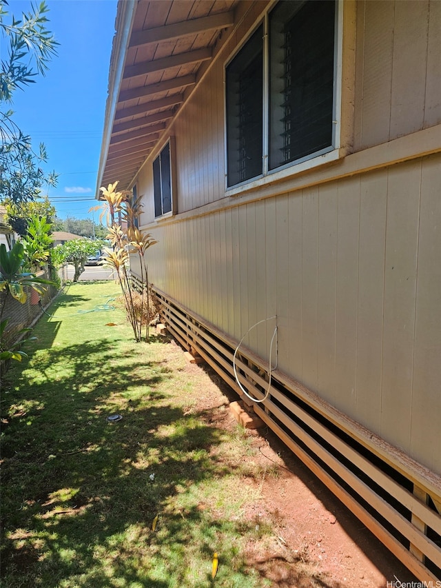 view of property exterior featuring fence and a lawn