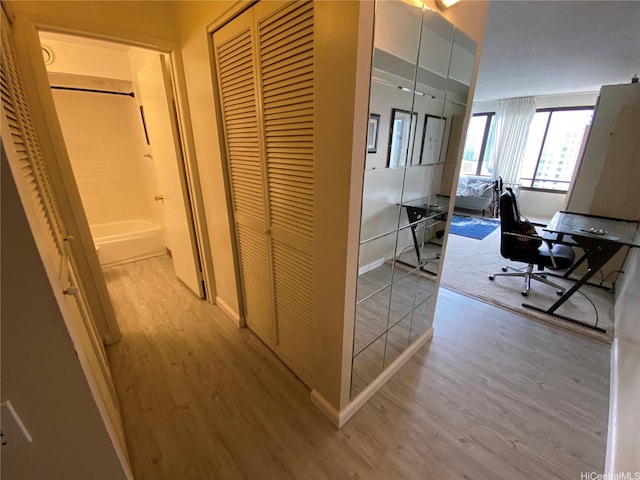 corridor with wood finished floors and an office area