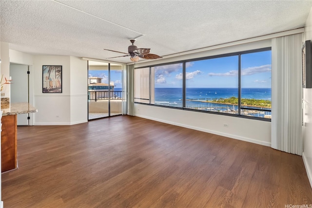 1778 Ala Moana Blvd Unit 3411, Honolulu, HI 96815 - spare room with ceiling fan, a textured ceiling, dark wood-style flooring, and a water view