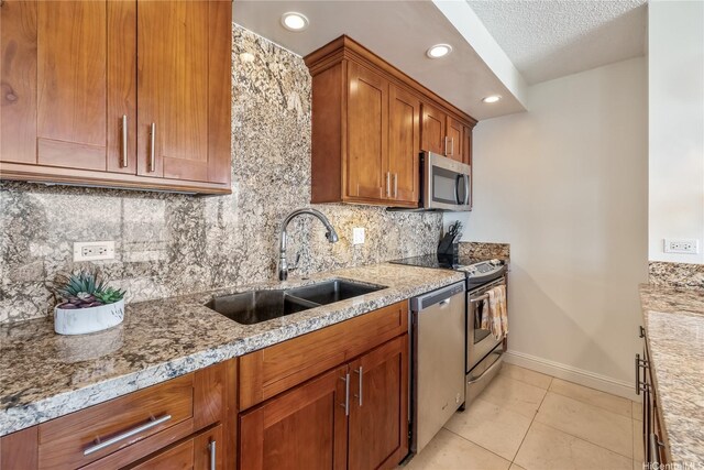 1778 Ala Moana Blvd Unit 3411, Honolulu, HI 96815 - kitchen with appliances with stainless steel finishes, a sink, baseboards, brown cabinetry, and light tile patterned flooring