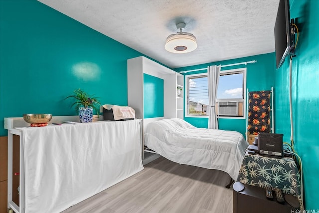 3003 Ala Napuaa Pl Unit 401, Honolulu, HI 96818 - bedroom with cooling unit, a textured ceiling, and wood finished floors