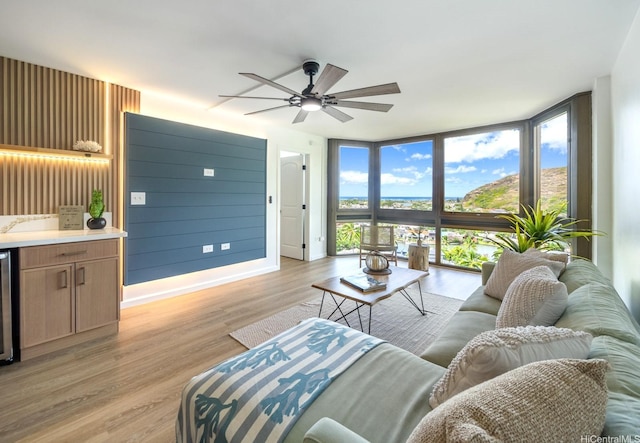 501 Hahaione St Unit 111D, Honolulu, HI 96825 - living area with a wall of windows, ceiling fan, light wood-style flooring, baseboards, and beverage cooler