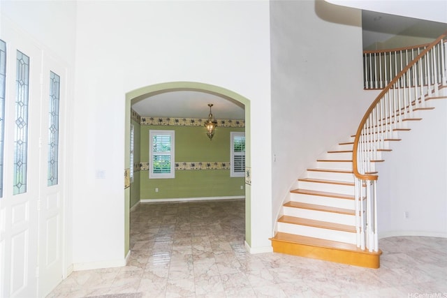 91-1027 Kaikoele St, Ewa Beach, HI 96706 - entryway featuring arched walkways, a towering ceiling, stairway, and baseboards
