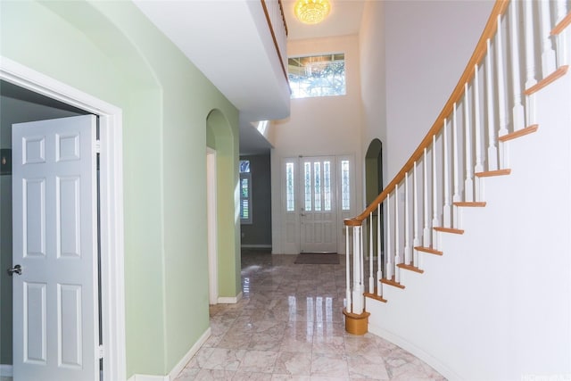 91-1027 Kaikoele St, Ewa Beach, HI 96706 - entrance foyer with marble tiled flooring, arched walkways, baseboards, stairs, and a high ceiling