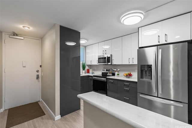 750 Kaheka St Unit 901, Honolulu, HI 96814 - kitchen with stainless steel appliances, light wood-type flooring, light countertops, white cabinets, and baseboards