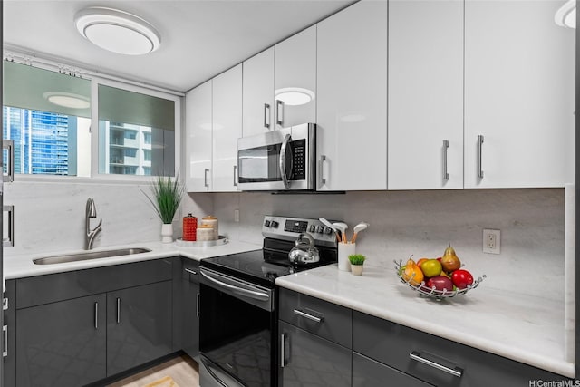 750 Kaheka St Unit 901, Honolulu, HI 96814 - kitchen with stainless steel appliances, a sink, white cabinetry, and light countertops