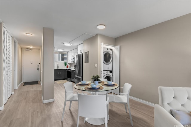 750 Kaheka St Unit 901, Honolulu, HI 96814 - dining area with stacked washer / drying machine, light wood finished floors, and baseboards
