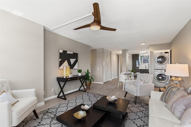 750 Kaheka St Unit 901, Honolulu, HI 96814 - living room featuring stacked washing machine and dryer, baseboards, wood finished floors, and ceiling fan