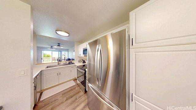 92-1226 Palahia St Unit Cc105, Kapolei, HI 96707 - kitchen featuring stainless steel appliances, light wood-style flooring, a sink, and white cabinetry