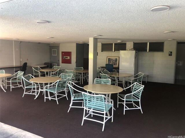 647 Kunawai Ln Unit A507, Honolulu, HI 96817 - dining room featuring a textured ceiling and concrete block wall