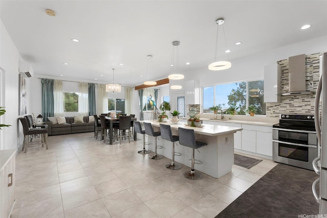 45-333 Mahalani St, Kaneohe, HI 96744 - kitchen featuring stainless steel appliances, light countertops, a kitchen island, white cabinets, and a kitchen breakfast bar
