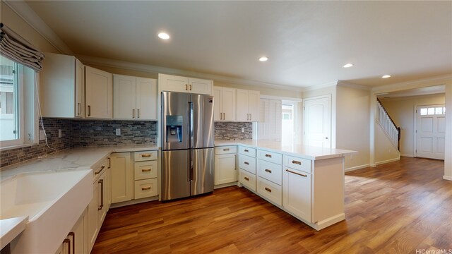84-575 Kili Dr Unit 8, Waianae, HI 96792 - kitchen featuring stainless steel fridge, a peninsula, ornamental molding, light wood-type flooring, and tasteful backsplash