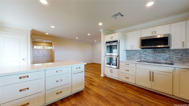 84-575 Kili Dr Unit 8, Waianae, HI 96792 - kitchen featuring stainless steel appliances, crown molding, backsplash, light countertops, and light wood finished floors