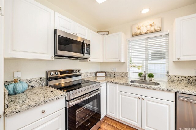 91-6414 Kapolei Pkwy, Ewa Beach, HI 96706 - kitchen with stainless steel appliances, a sink, white cabinets, recessed lighting, and light stone countertops