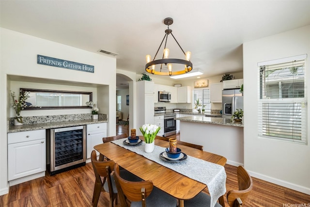 91-6414 Kapolei Pkwy, Ewa Beach, HI 96706 - dining area featuring wine cooler, dark wood finished floors, arched walkways, a chandelier, and baseboards