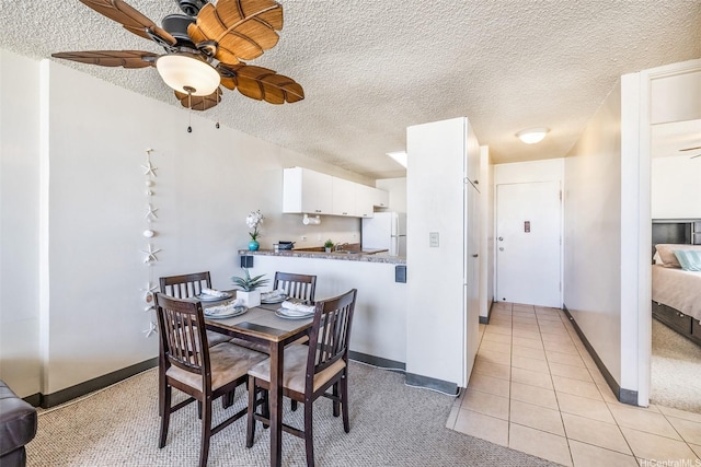 1805 Poki St Unit 1101, Honolulu, HI 96822 - dining space featuring ceiling fan, a textured ceiling, light tile patterned floors, and baseboards