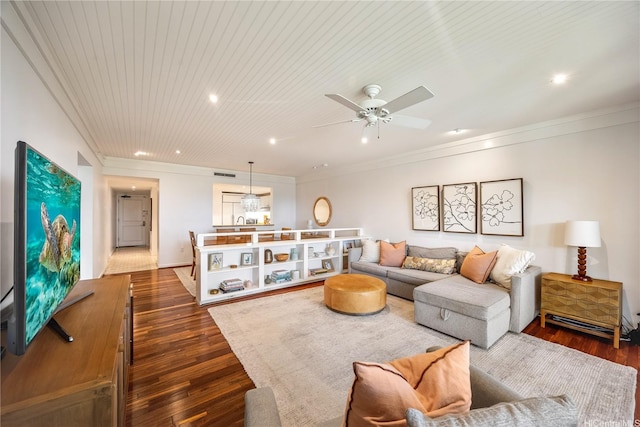 living area featuring dark wood-style flooring, a ceiling fan, ornamental molding, and recessed lighting