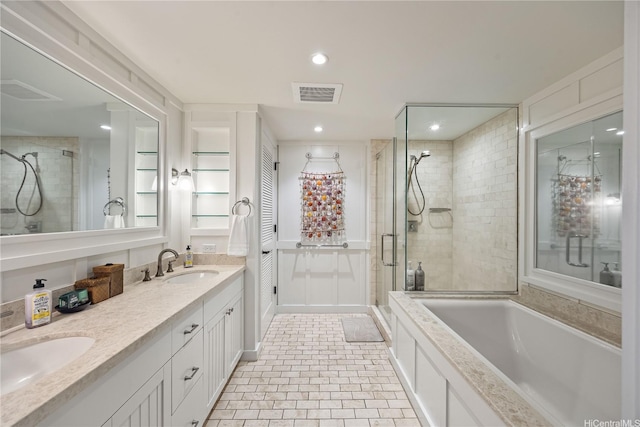 bathroom featuring double vanity, visible vents, a stall shower, and a sink
