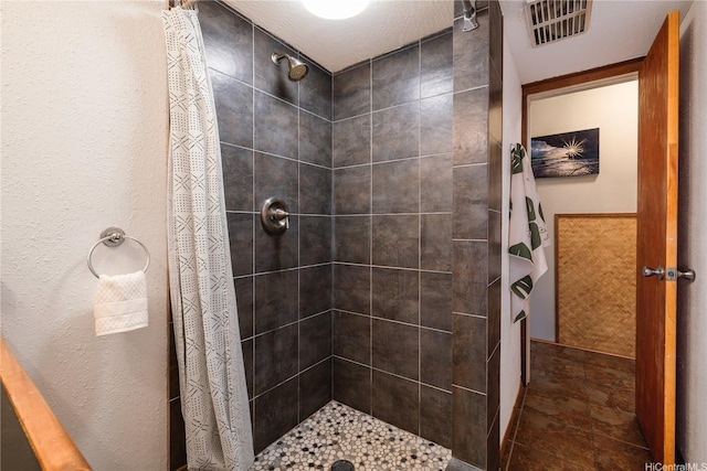 bathroom featuring tiled shower and visible vents