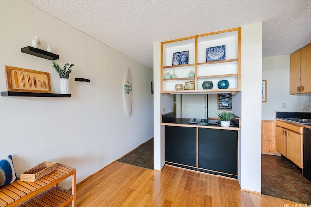 kitchen featuring a sink, a textured ceiling, and wood finished floors
