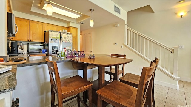 92-1490 Aliinui Dr Unit 803, Kapolei, HI 96707 - kitchen featuring appliances with stainless steel finishes, dark countertops, light tile patterned floors, a peninsula, and hanging light fixtures