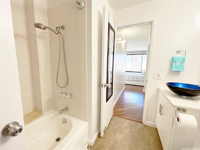 full bathroom featuring shower / tub combination, wood finished floors, vanity, connected bathroom, and baseboards