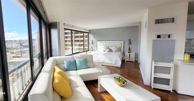 bedroom featuring dark wood-style flooring and a city view