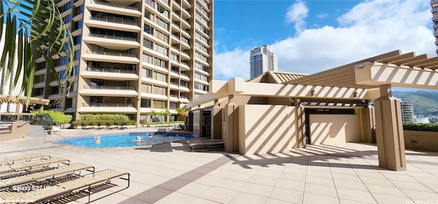 community pool with a pergola and a patio area